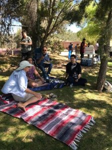 The folks from the registrar's office, the president's office and financial aid, sit beneath a tree enjoying some conversation and gorgeous weather.